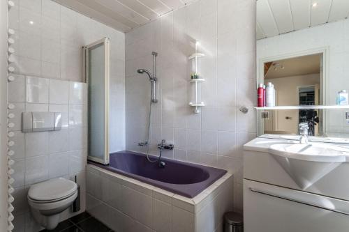 een badkamer met een wastafel, een bad en een toilet bij Btween Maas & Waal in Druten