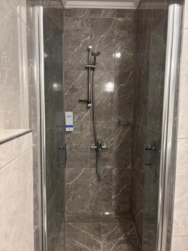 a shower with a glass door in a bathroom at Dores Residence in Turunç