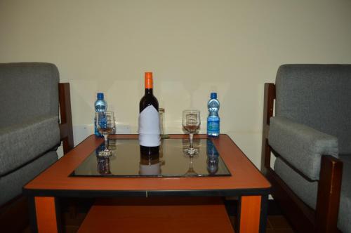 a bottle of wine and two glasses on a table at Harbe Hotel in Lalībela