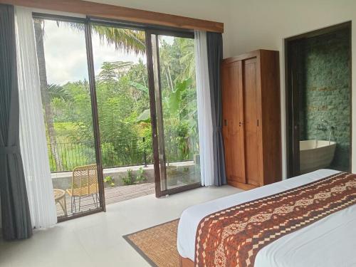 una camera da letto con un letto e una grande finestra di The Samudra Ubud Villa ad Ubud
