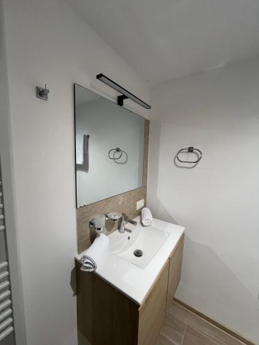 a bathroom with a sink and a mirror at Vila Soleil in Azuga