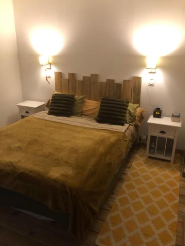 ein Schlafzimmer mit einem großen Bett mit zwei Nachttischen in der Unterkunft L Orée du Bois in Agnetz