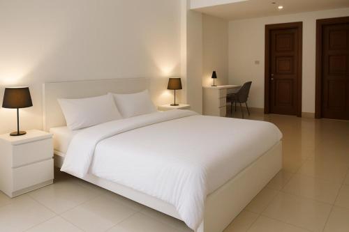 a bedroom with a large white bed and a desk at Townhouse in Golden Mile 3BR in Dubai
