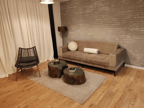 a living room with a couch and a table and a chair at Monastery 2 Aparthotel in Pamporovo