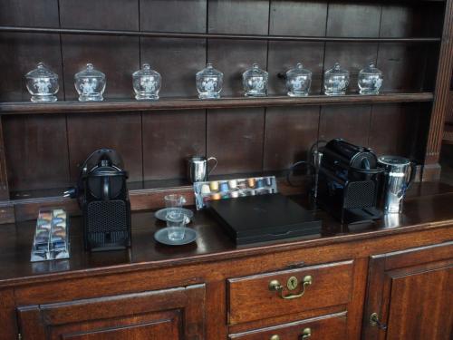 a wooden counter with a phone and a coffee maker on it at Hotel Vorsen in Gingelom