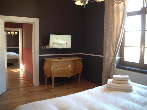 a bedroom with a bed and a table and a window at Hotel Vorsen in Gingelom