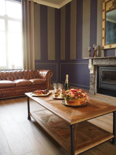 a living room with a table with food and wine glasses at Hotel Vorsen in Gingelom