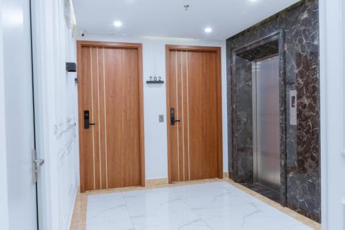 pasillo con 2 puertas de madera en una habitación en Hotel Villa Ju, en Hanói