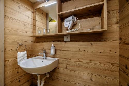 a bathroom with a white sink and wooden walls at Agriturismo Vultaggio in Guarrato