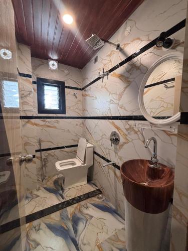 a bathroom with a toilet and a sink at Hotel Mukti Residency in Mātigara
