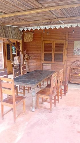 un tavolo e sedie in legno su un patio di Danae Beach Golf a Nosy Be