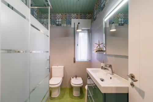 a bathroom with a sink and a toilet and a mirror at Casa La Quinta in Colindres