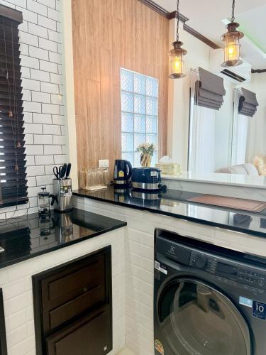 a kitchen with a washing machine under a counter at PS House Bangtao in Bang Tao Beach