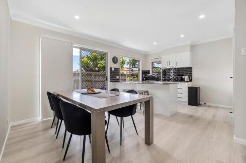 a kitchen and dining room with a table and chairs at 3 Bedroom Fully Renovated Home away from Home in Brisbane