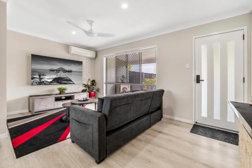 a living room with a couch and a tv at 3 Bedroom Fully Renovated Home away from Home in Brisbane