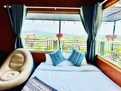 1 cama y 1 silla en una habitación con ventana en A La Mer Măng Đen, en Kon Plong