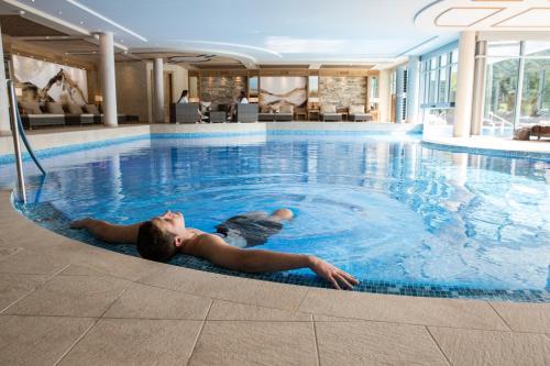 uma mulher deitada numa piscina em Meiser Vital Hotel em Fichtenau