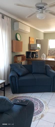 un salon avec un canapé bleu et une cuisine dans l'établissement Budler Stay, à Upington