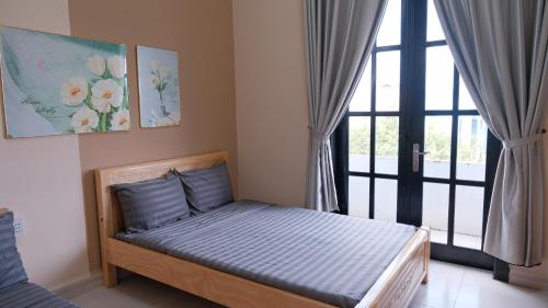 a small bed in a room with a window at Khách Sạn Đối Ngoại Biên Phòng in Buon Ma Thuot