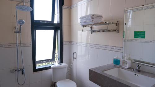 a bathroom with a toilet and a sink and a shower at Khách Sạn Đối Ngoại Biên Phòng in Buon Ma Thuot