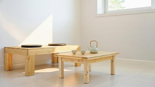 ein Tisch und eine Bank mit Schüsseln und einem Krug darauf in der Unterkunft Gangneung Lacblanc Pension in Gangneung