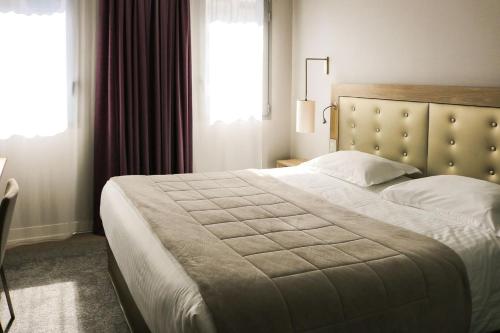 Hôtel Anne De Bretagne في رين: غرفة نوم بسرير كبير ونافذة