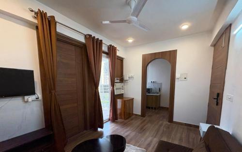 een woonkamer met een schuifdeur en een televisie bij WeHymn Homes 607 in Gomti Nagar