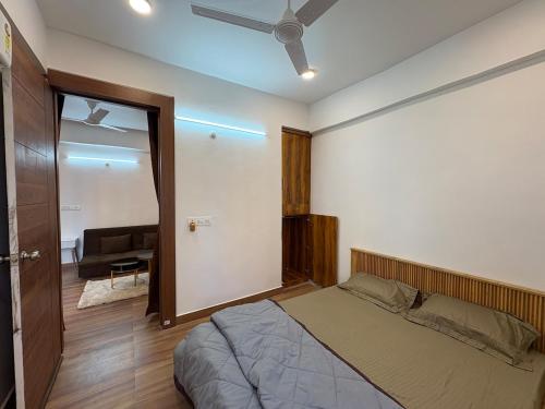 een slaapkamer met een bed en een plafondventilator bij WeHymn Homes 607 in Gomti Nagar