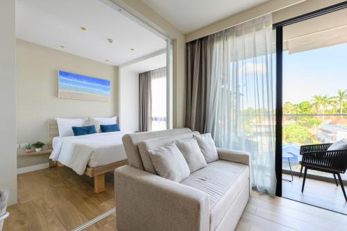 ein Hotelzimmer mit einem Bett und einer Couch in der Unterkunft Stylish apartment close to Bang Tao beach in Strand Bang Tao