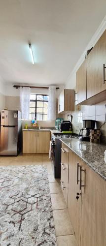 een grote keuken met houten kasten en roestvrijstalen apparatuur bij Homebound stays in Nairobi