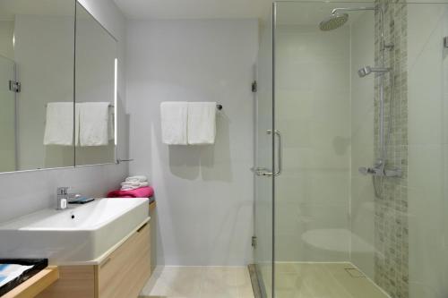 ein Badezimmer mit Glasdusche und Waschbecken in der Unterkunft Stylish apartment close to Bang Tao beach in Strand Bang Tao