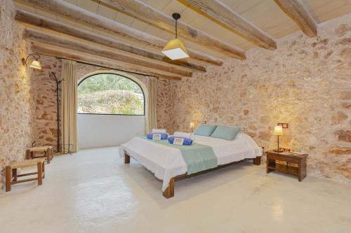 una camera da letto con un letto in un muro di pietra di Villa Can Granot a Caʼs Concos