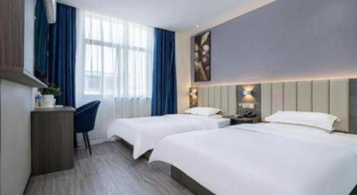 Una cama o camas en una habitación de 7 Days Inn Luoyang Railway Station Wangcheng Avenue