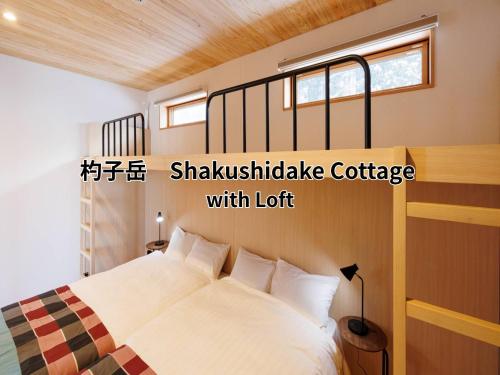 a bedroom with a bed with white sheets and a window at Hakuba Highland Hotel in Hakuba