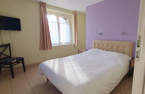 En eller flere senge i et værelse på Manoir Le Castel & Villa Beaumaris