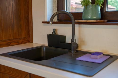 a kitchen sink with a faucet and a purple towel at Villa Brusiana with heated pool in Brušane