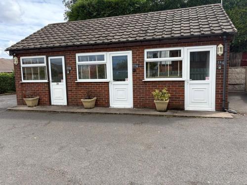 uma pequena casa de tijolos com portas e janelas brancas em Central Hotel em Sutton in Ashfield
