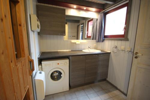 a small kitchen with a washing machine and a sink at Wildgans 87 in Mirow