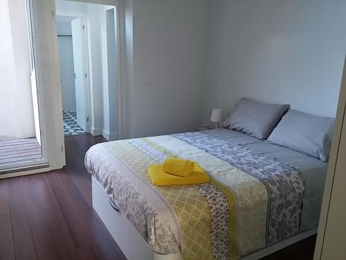 ポルトにあるOporto Downtown Apartmentのベッドルーム1室(黄色の帽子付きのベッド1台付)