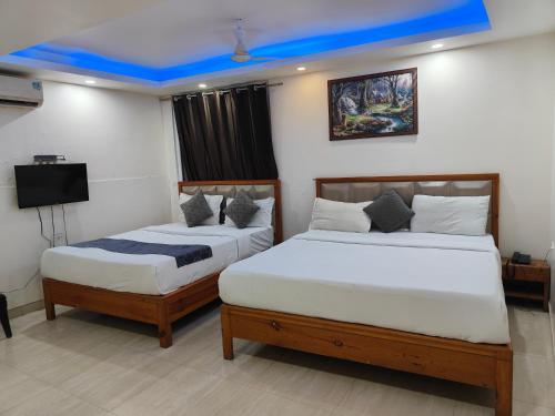 JāmbにあるHotel Royal Plaza At IGI Airportのベッドルーム(ベッド2台、テレビ付)