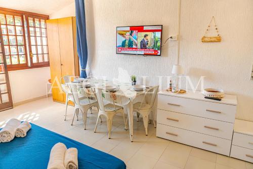 ein Esszimmer mit einem Tisch und einem Fernseher an der Wand in der Unterkunft Pesciolino Blu in Campese