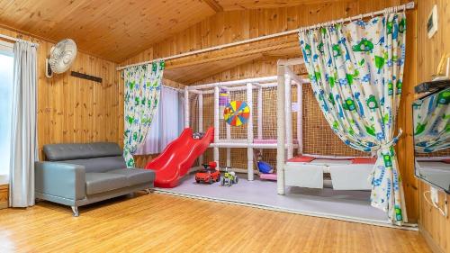 a childs room with a slide and a chair at Gapyeong Yeoul kids pension in Gapyeong