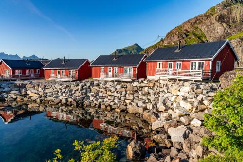 レクネスにあるStatles Rorbu- og Konferansesenter ASの岩壁の隣に並ぶ赤い家々