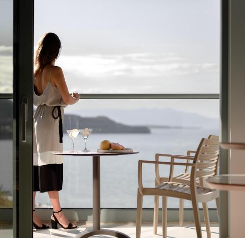 库基尼坎尼奥Arina Beach Resort的一位女士站在摆放着眼镜的桌子旁。