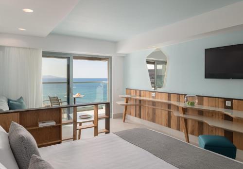 库基尼坎尼奥Arina Beach Resort的一间卧室设有一张床、一台电视和一个阳台。