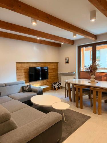 a living room with a couch and a table at Apartamenty Gubałówka in Zakopane