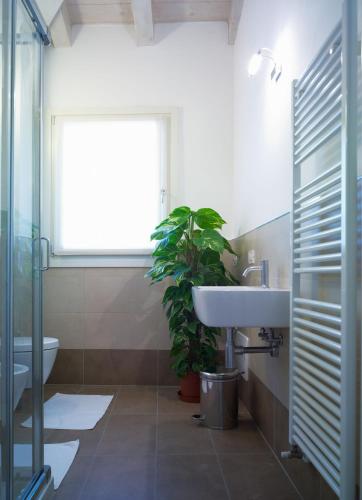 a bathroom with a sink and a potted plant at Corte Trambai in Gambellara