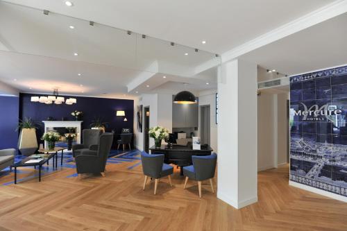 a lobby with chairs and a table in a building at Mercure Paris Saint Cloud Hippodrome in Saint-Cloud