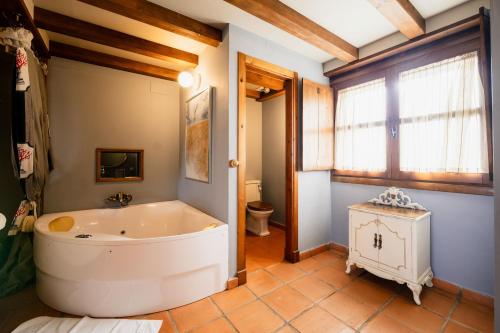 un ampio bagno con vasca e WC di Hotel Boutique Barosse Family & Pet Friendly Roo a Jaca