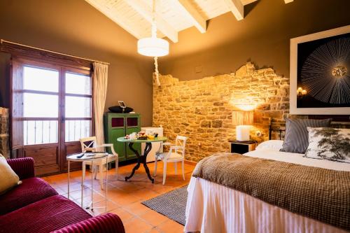 una camera da letto con un letto e un tavolo con sedie di Hotel Boutique Barosse Family & Pet Friendly Roo a Jaca
